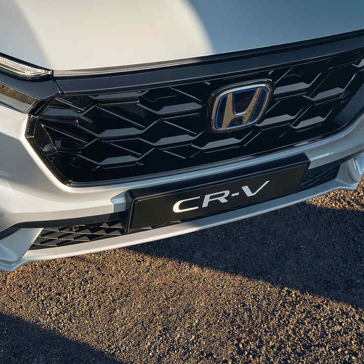 Közeli kép a Honda CR-V Hybrid gépkocsi elülső hűtőrácsáról.