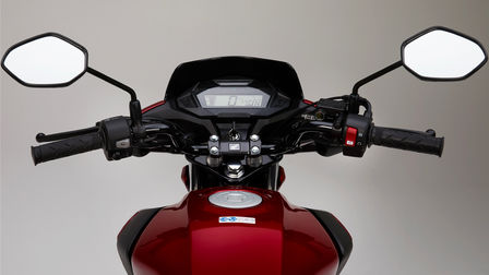 Stúdiófelvétel egy piros Honda CB125F motorkerékpárról, fókuszban az LCD-kijelző