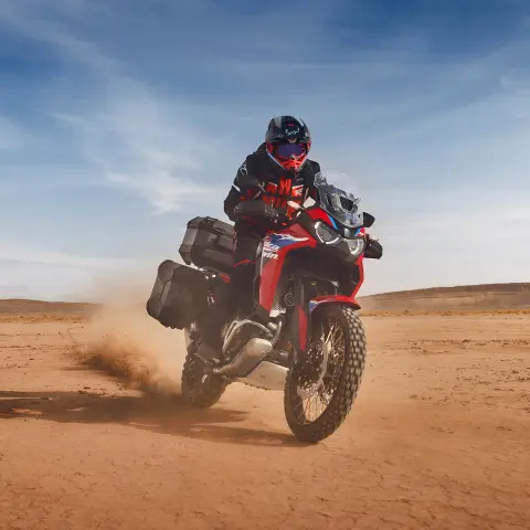Motoros a Honda CRF1100 Africa Twin Adventure Sport nyergében sivatagi környezetben.