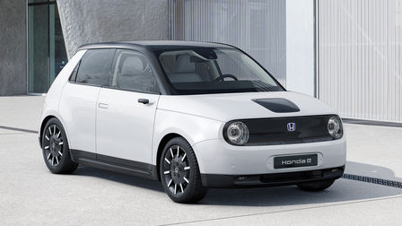 Háromnegyedes elülső felvétel egy leparkolt Honda e modellről, a háttérben épületekkel.