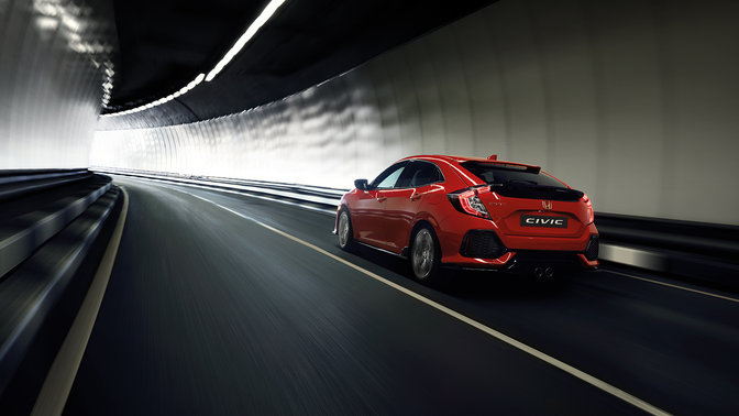 Háromnegyedes felvétel egy alagútban haladó Honda Civic hátuljáról.
