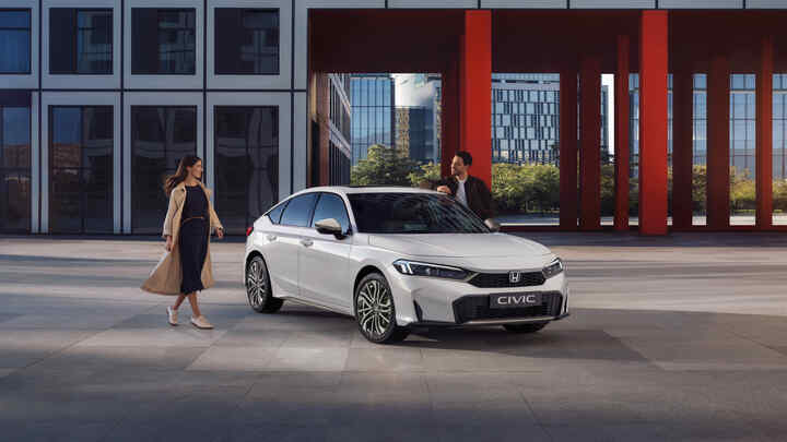 Egy Civic Hybridhez sétáló emberek.