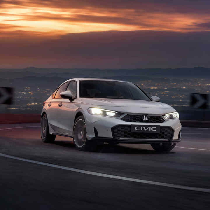 Honda Civic Hybrid mozgásban az autópályán, szürkületben.