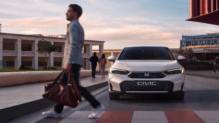 Honda Civic Hybrid közeledik egy gyalogos-átkelőhely előtt álló férfihoz.