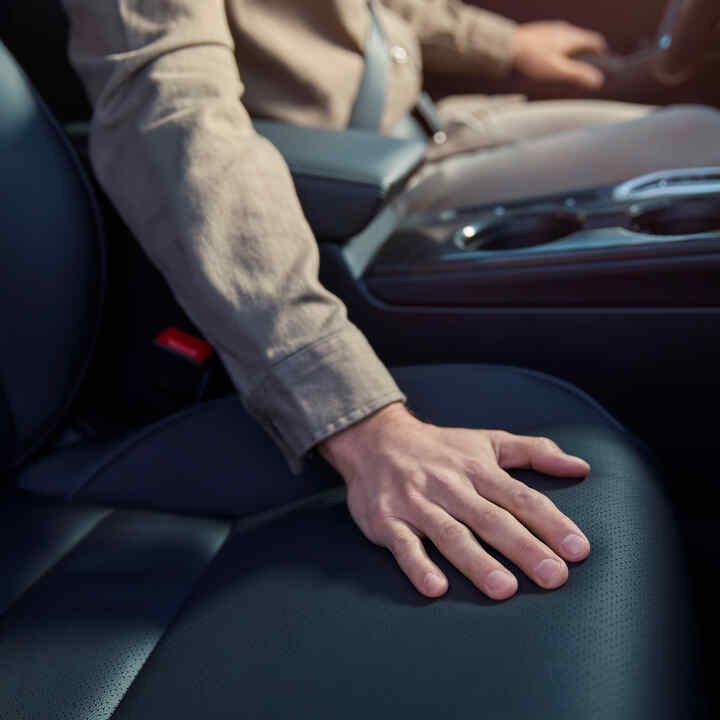 Közelkép egy emberi kézről a Honda Civic Hybrid ülésén.
