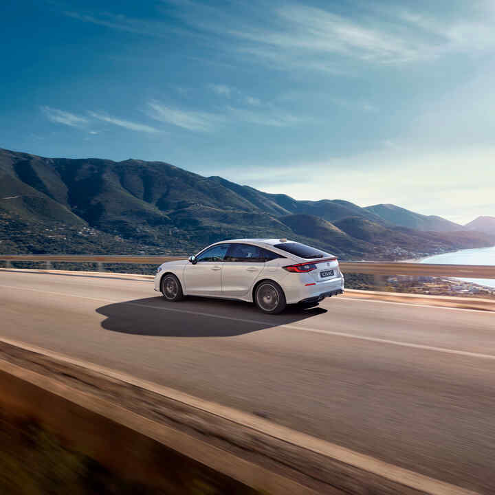 Honda Civic Hybrid in motion on a highway, in a scenic view.