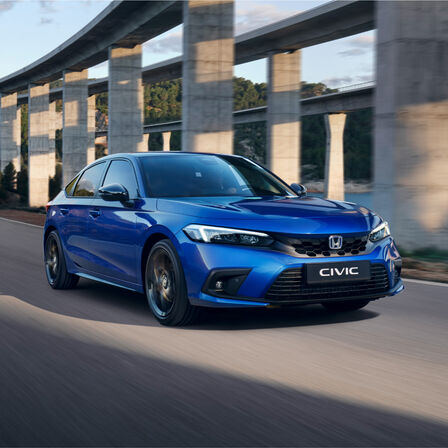 Háromnegyedes felvétel a hibrid Honda Civic elejéről, tóparti kép.