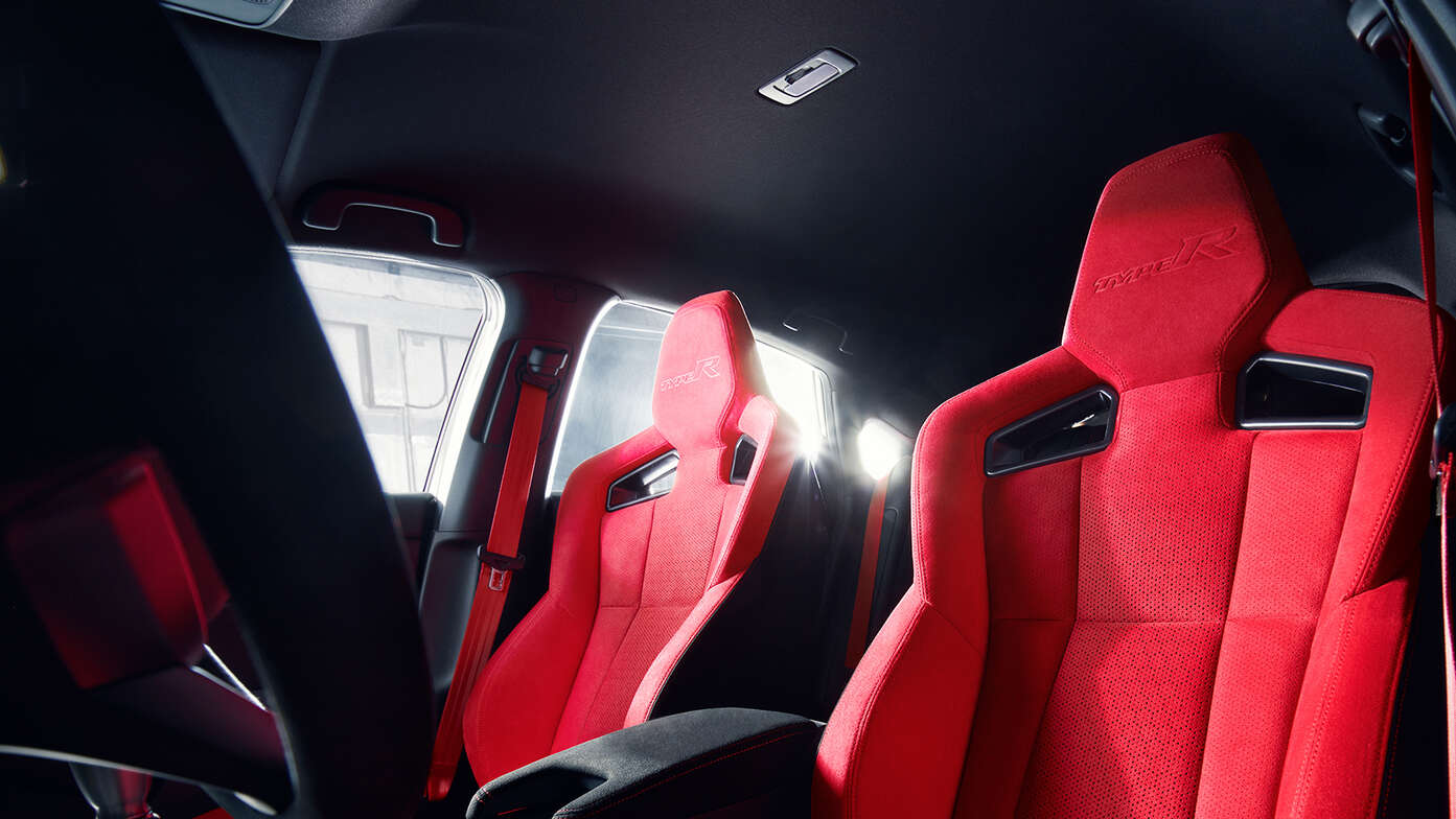 Közeli kép a Honda Civic Type R piros velúrkárpitozásáról.