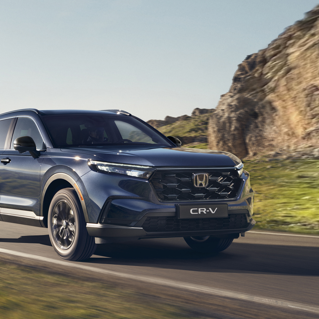 Háromnegyed-profilos elölnézeti kép a Honda CR-V Hybrid gépkocsiról hegyvidéki környezetben, menet közben.
