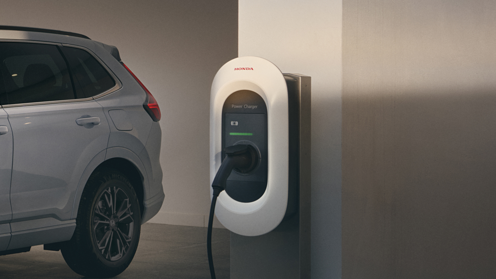 Háromnegyed-profilos elölnézeti kép a Honda CR-V Hybrid gépkocsiról töltés közben.
