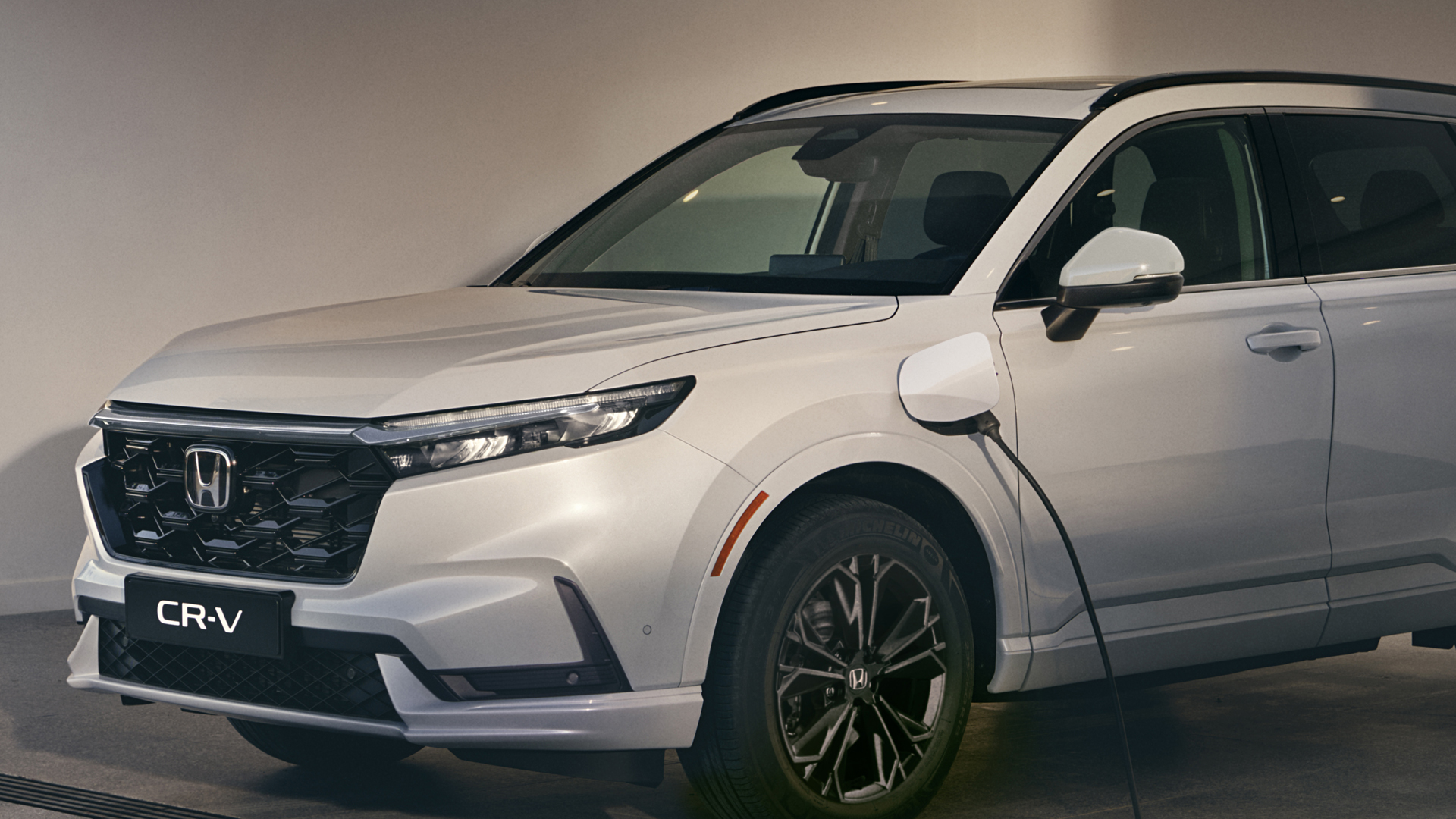Közeli kép a Honda töltőről és a Honda CR-V Hybridről.