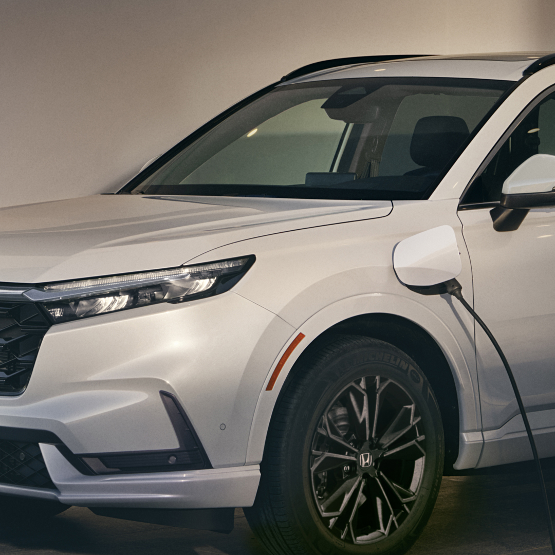 Közeli kép a Honda töltőről és a Honda CR-V Hybridről.
