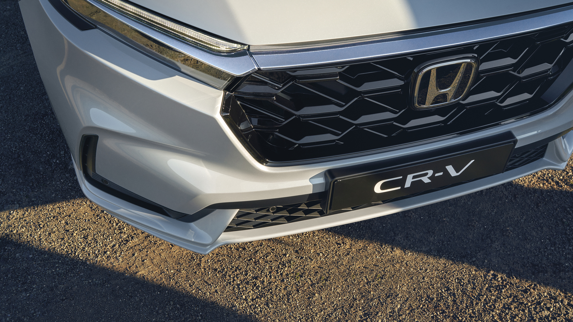 Közeli kép a Honda CR-V Hybrid gépkocsi elülső hűtőrácsáról.