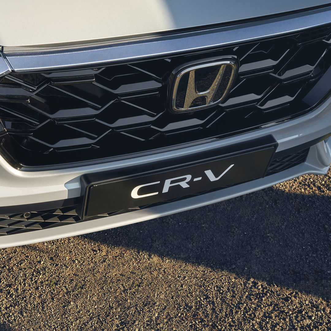Közeli kép a Honda CR-V Hybrid gépkocsi elülső hűtőrácsáról.