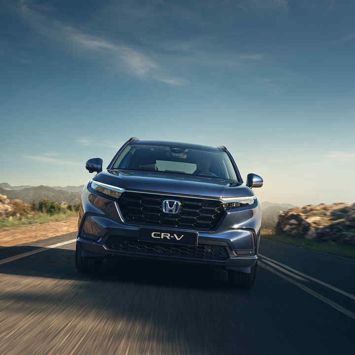 Hegyvidéki úton haladó Honda CR-V Hybrid elölről.