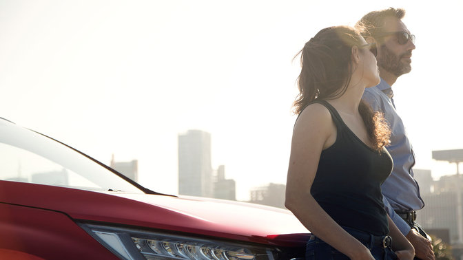 Közelkép a Honda CR-V első lökhárítójáról sofőrrel és utassal.