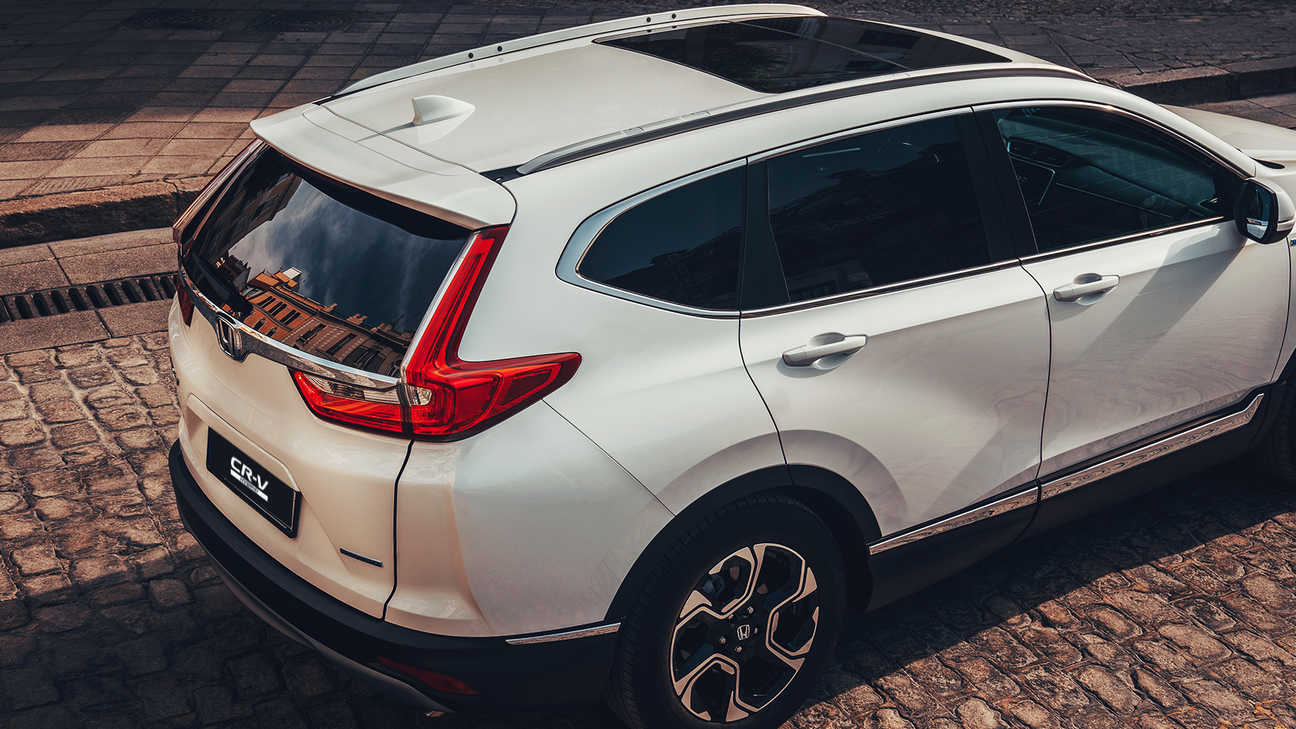 Hátulnézeti kép a Honda CR-V hibrid gépkocsiról utcai környezetben.