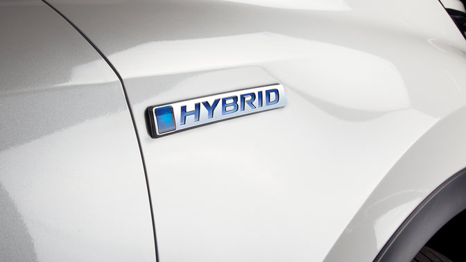 Közeli oldalnézeti kép a Honda CR-V hibrid emblémájáról.