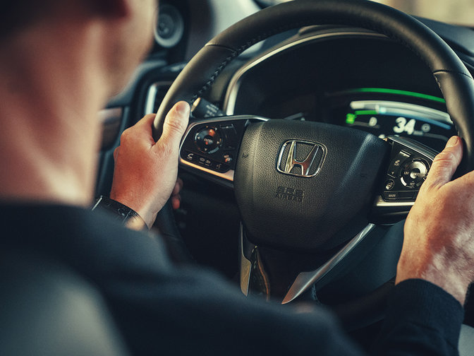 Háromnegyed-profilos közeli oldalnézeti kép a Honda CR-V hibrid kormánykerekéről.