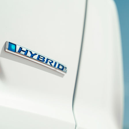 Közelkép a Honda CR-V hibrid emblémájáról.