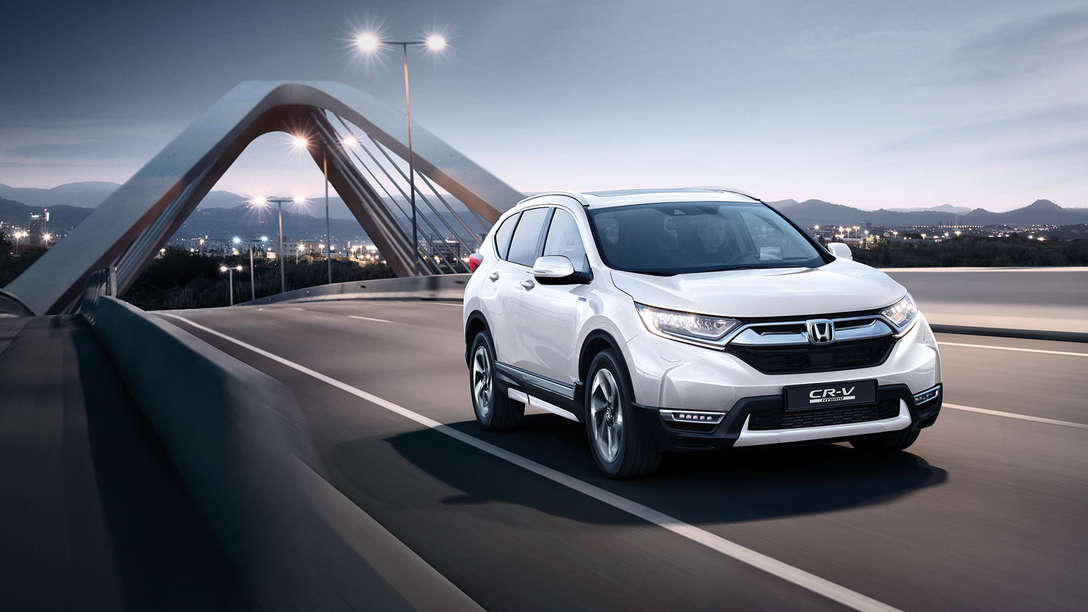 Háromnegyed-profilos elölnézeti kép a Honda CR-V hibrid gépkocsiról utcai környezetben.