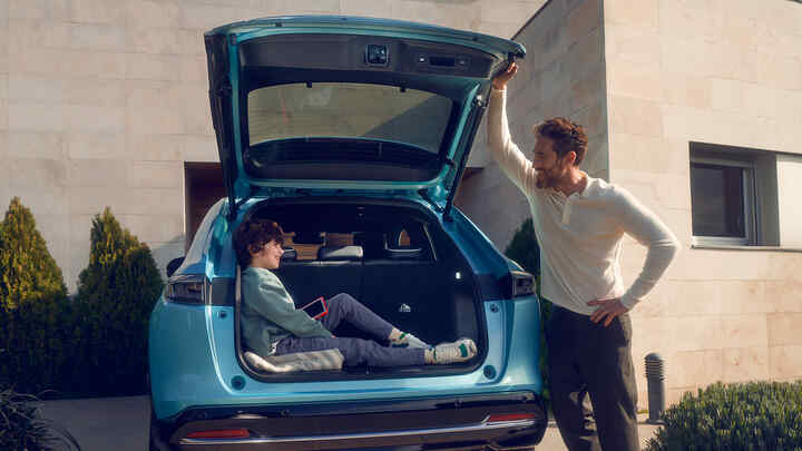 Egy apa beszél a Honda e:Ny1 csomagtartójában ülő gyerekhez.