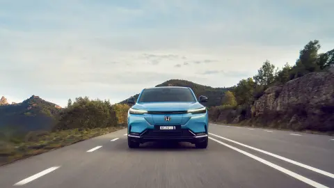 Honda e:Ny1 elölről, amely egy hegyvidéki úton halad. 
