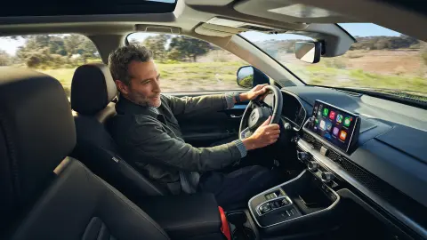 Egy modell a CR-V Hybrid belsejében ül, és a Honda Sensing 360 funkciót használja.
