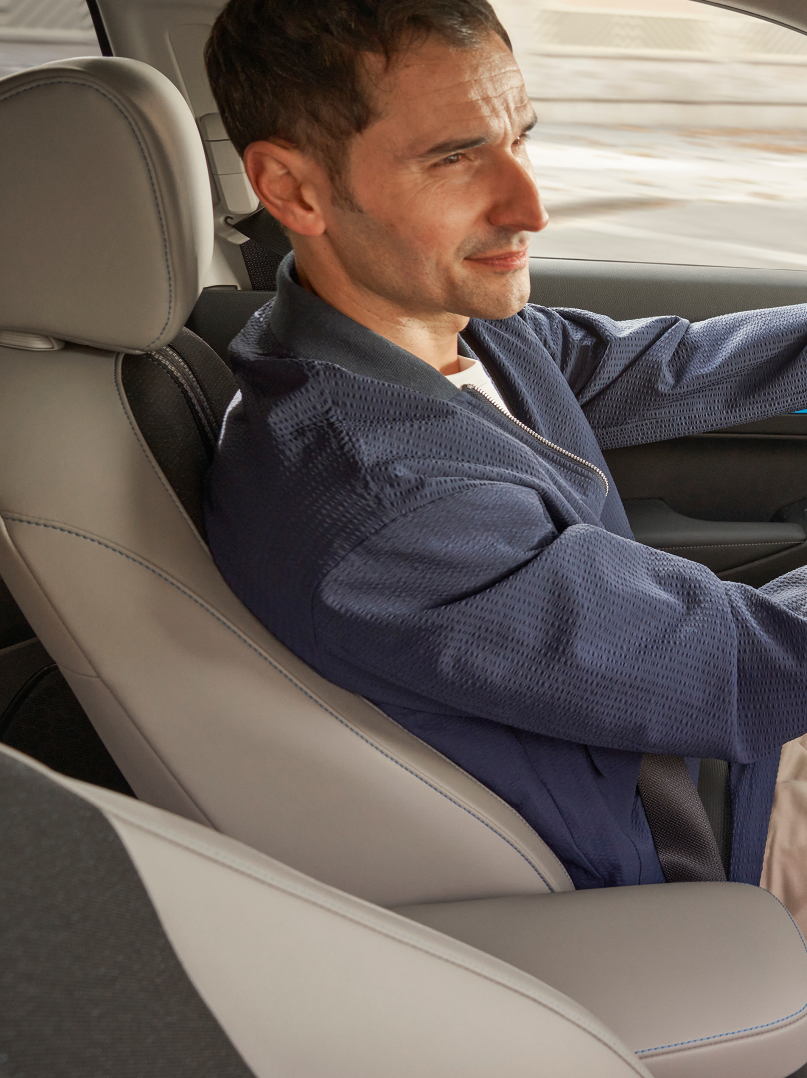 Vezető ül egy Honda HR-V volánja mögött, az első utas felől nézve, miközben a belső műszerfal és a központi képernyőn a navigációs térkép látható.
