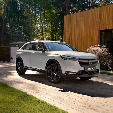 Háromnegyedes felvétel a Honda HR-V Hybrid elejéről, amely egy kocsibeállóban parkol