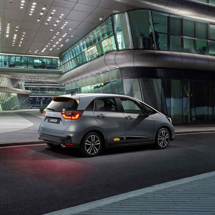 Háromnegyedes elülső nézet egy Honda Jazz Hybrid autóról városi vezetés közben