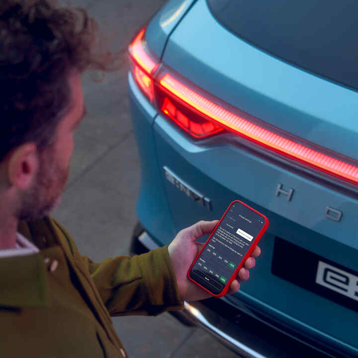 Közelkép egy személyről, aki az autóján kívül a My Honda+ alkalmazást használja.