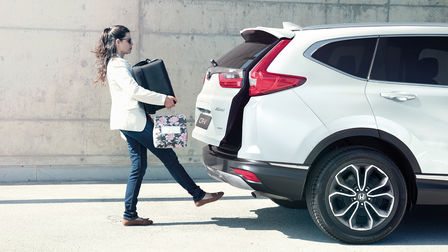 Egy CR-V hátuljánál csomagokat pakoló hölgy