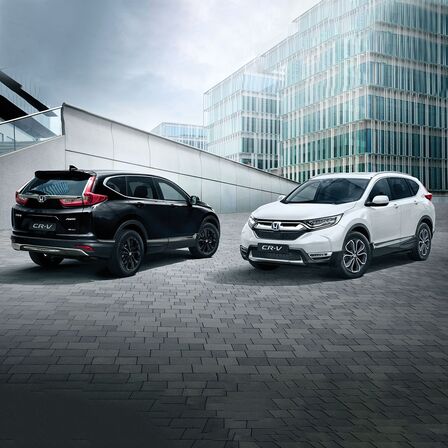 Két Honda CR-V, amelyek egy irodaépület előtt parkolnak
