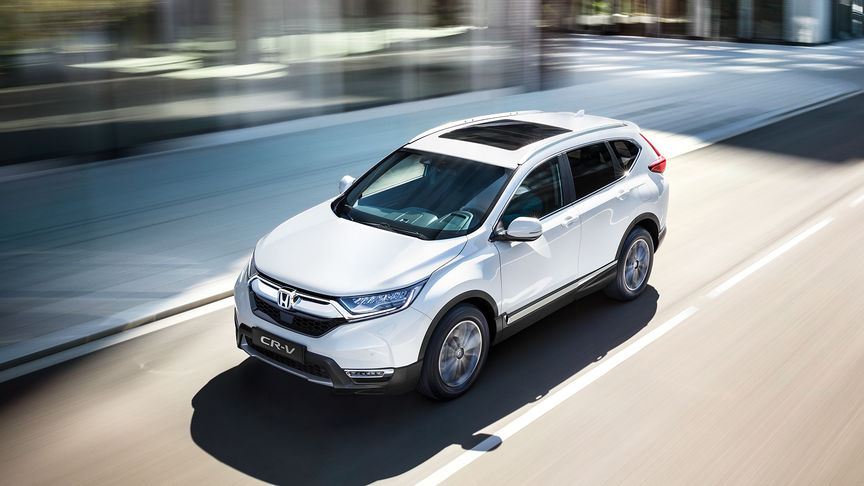 Háromnegyedes elülső felvétel egy Honda CR-V modellről, amely a városon halad keresztül