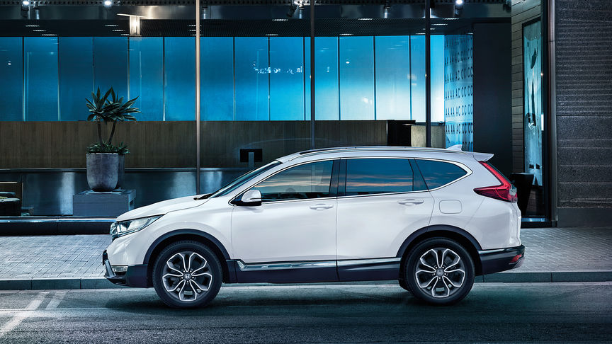 Háromnegyedes elülső felvétel egy Honda CR-V modellről, amely a városon halad keresztül