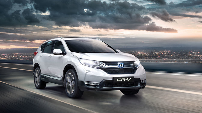 Háromnegyedes felvétel a Honda CR-V elejéről bekapcsolt távolsági fényszóróval