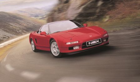 Háromnegyedes felvétel a Honda NSX elejéről vidéki környezetben.