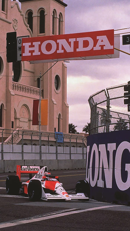 Háromnegyedes felvétel egy Formula-1-es McLaren-Honda versenyautó elejéről versenypályán.