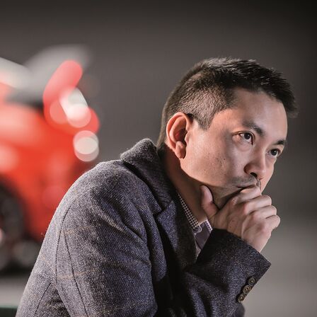 Ötajtós Honda Civic és gondolkozó férfi oldalnézetből.