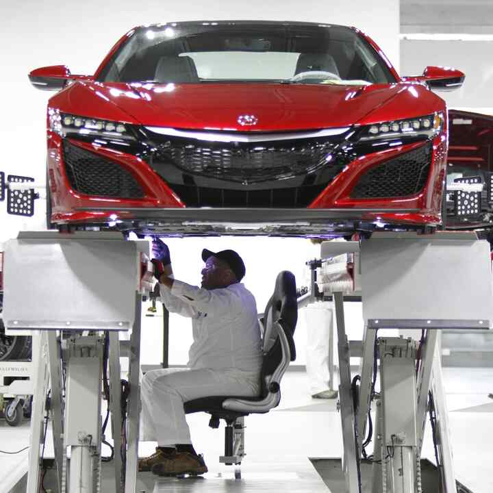 Honda-technikus dolgozik egy szemből látható NSX-modellen.