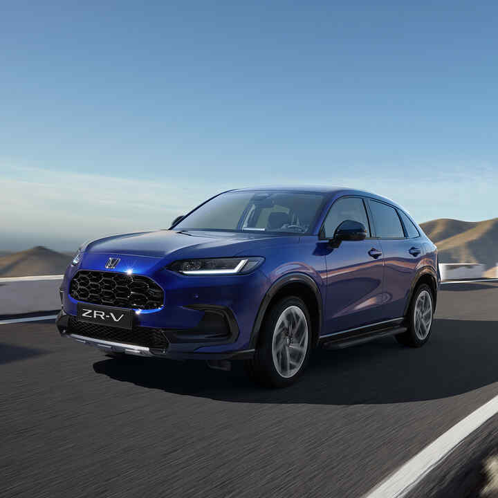 Elölről készült, háromnegyed felvétel a Honda ZR-V-ről a Robust csomaggal hegyvidéki környezetben.