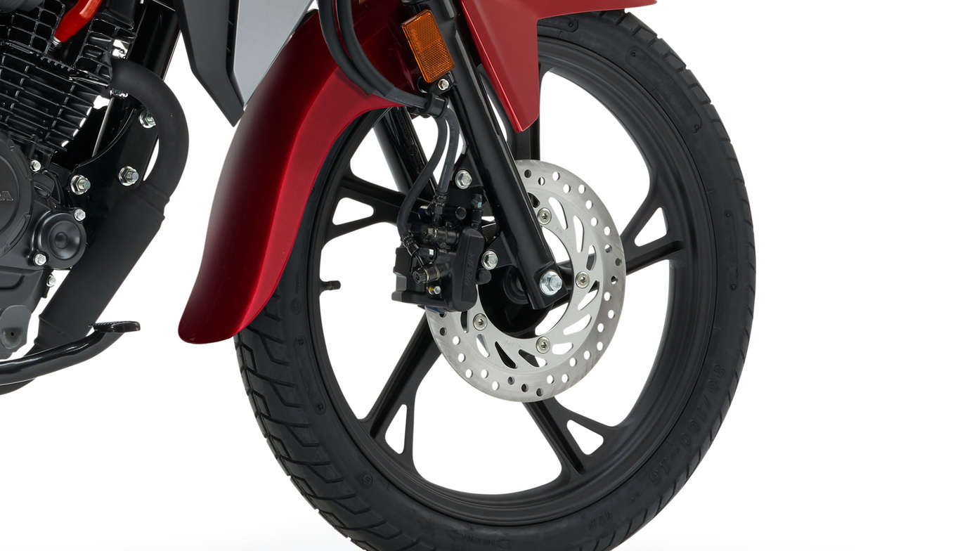 Piros Honda CB125F stúdiófelvételen, amely az első kerékre és a fékre fókuszál