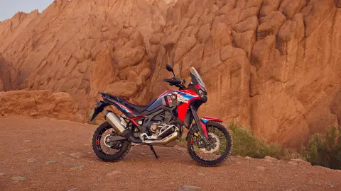 A CRF1100L Africa twin motorkerékpár a sivatagban parkol.