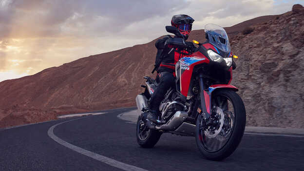 Fotómodell vezet egy CRF1100L Africa Twin motorkerékpárt a sivatagban.