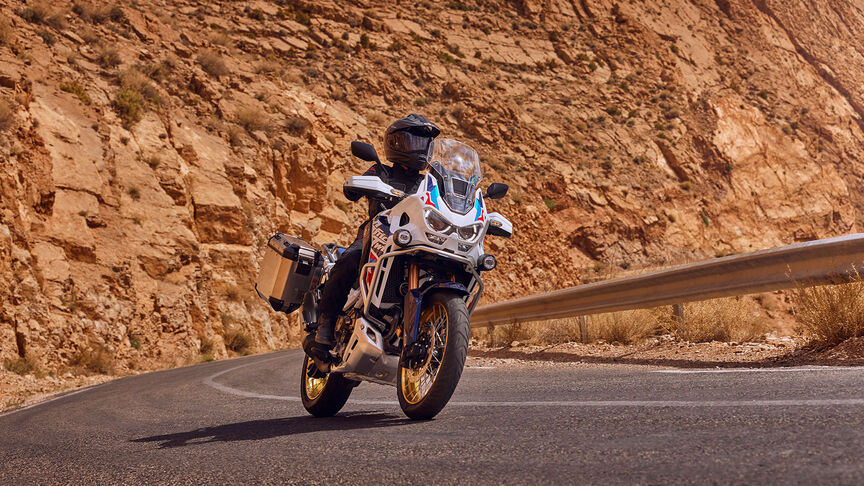 A Honda CRF1100 Africa Twin Adventure Sports eleje háromnegyedes kompozícióban, hegyvidéki környezetben.