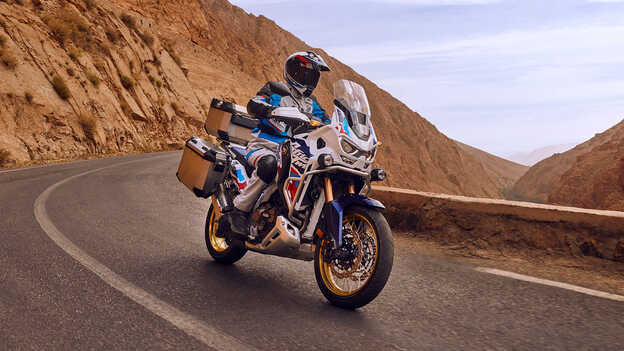 Motoros a Honda CRF1100 Africa Twin Adventure Sports nyergében, elölnézetből, sivatagi környezetben.
