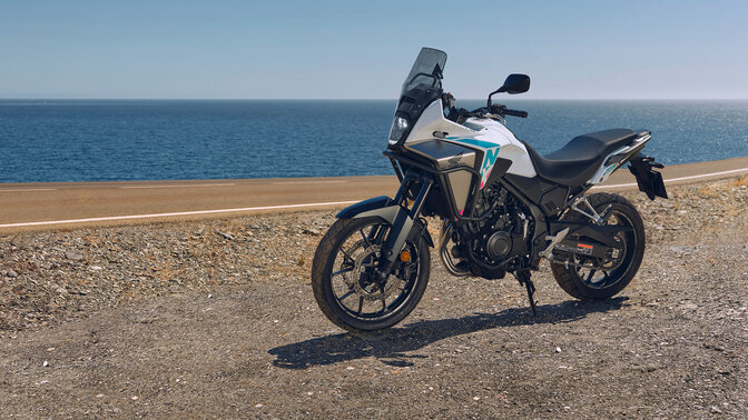 Honda NX500 – oldalról készült felvétel terepen, vízparti környezetben