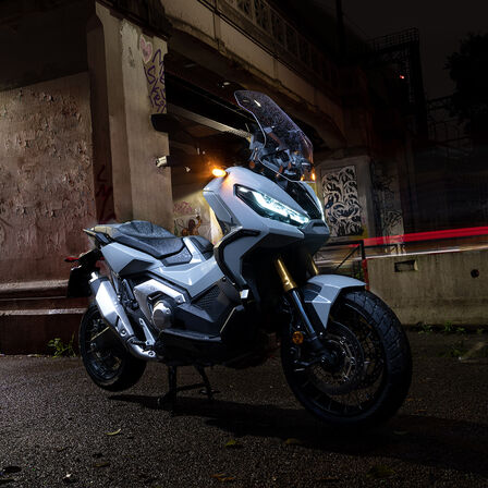 X-ADV álló helyzetben, elülső háromnegyedes felvétel, motorossal