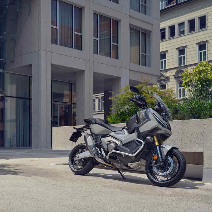 X-ADV motorkerékpár, amely egy városi kocsibeállón parkol.